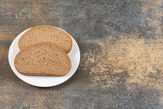 Rebanadas de pan de centeno en la placa blanca.