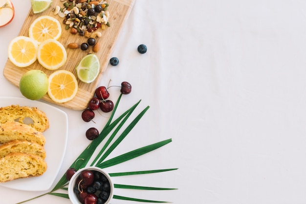 Rebanadas de pan; Cereza; Limón y frutos secos sobre fondo blanco