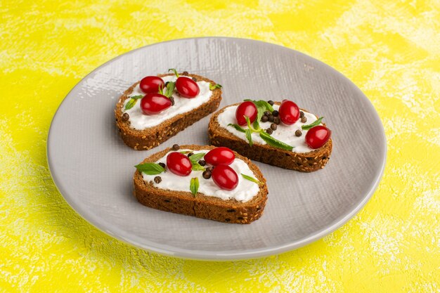 Rebanadas de pan con crema agria y cornejo sobre amarillo