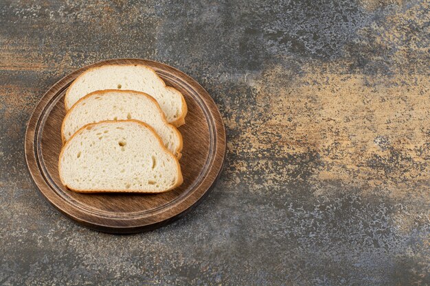 Rebanadas de pan fragante sobre tabla de cortar de madera