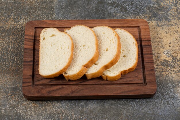 Rebanadas de pan fragante sobre tabla de madera.