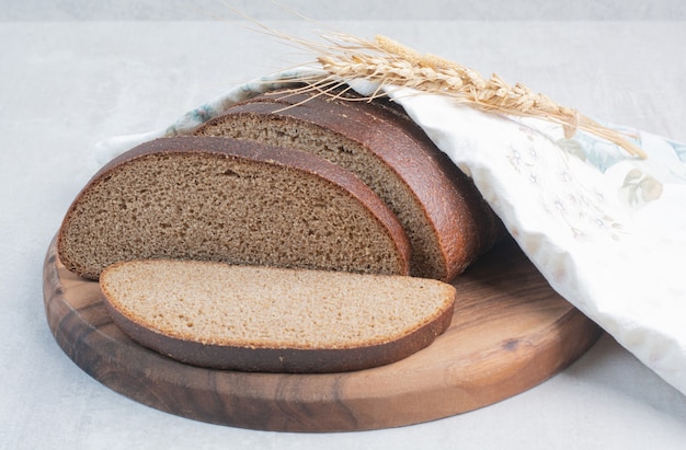 Rebanadas de pan fresco marrón sobre mantel.