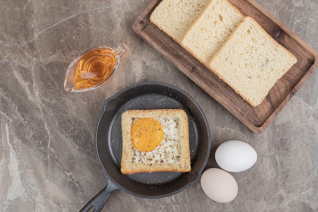 Rebanadas de pan, huevos y aceite sobre mesa de mármol. Foto de alta calidad