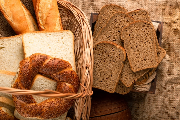 Rebanadas de pan integral en caja y panecillos con baguette en la cesta