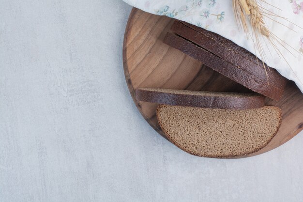 Rebanadas de pan integral fresco sobre tabla de madera.