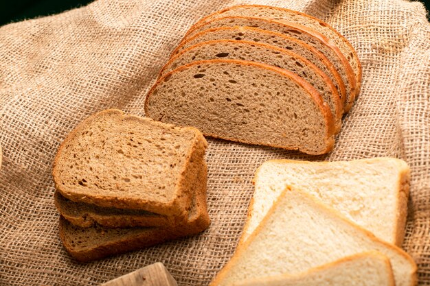 Rebanadas de pan oscuro y blanco en la tabla de la cocina