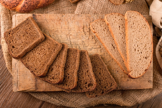 Rebanadas de pan oscuro y blanco en la tabla de la cocina