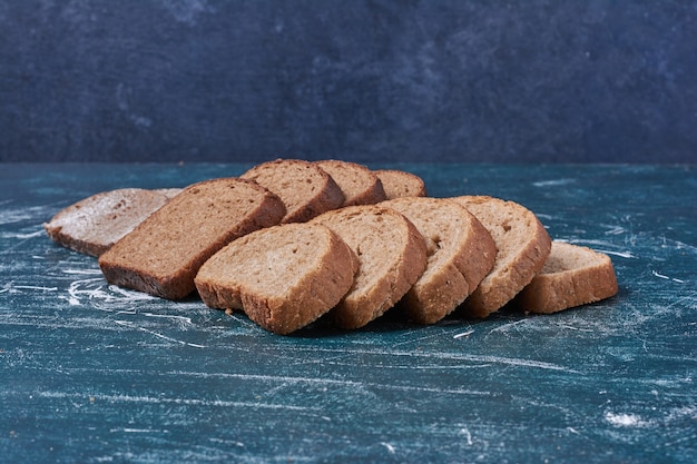 Foto gratuita rebanadas de pan oscuro en el cuadro azul.