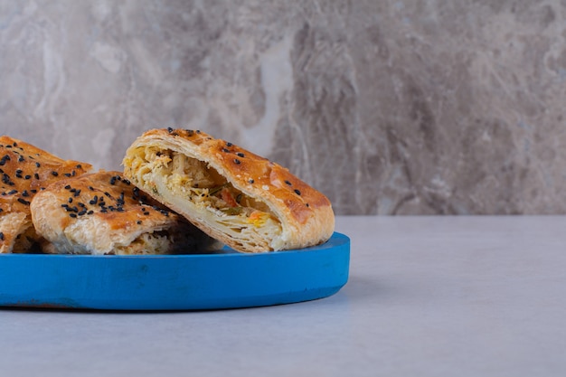 Foto gratuita rebanadas de pan con sésamo en la placa de madera sobre la superficie oscura