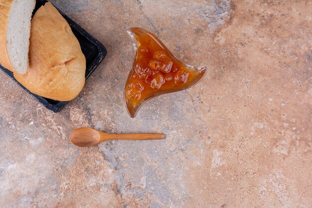 Rebanadas de pan con una taza de confitura de higos