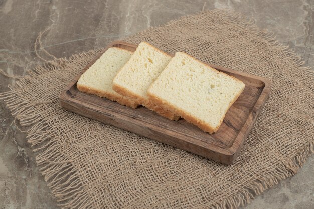 Rebanadas de pan tostado en placa de madera. Foto de alta calidad