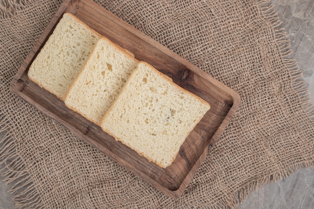 Rebanadas de pan tostado en placa de madera. Foto de alta calidad