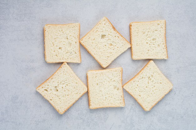 Rebanadas de pan tostado sobre fondo de mármol. Foto de alta calidad