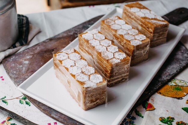 rebanadas de pastel diseñado crema marrón delicioso delicioso dentro del plato blanco