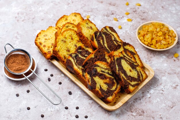 Rebanadas de pastel de mármol con pasas tradicionales con pasas y cacao en polvo, vista superior