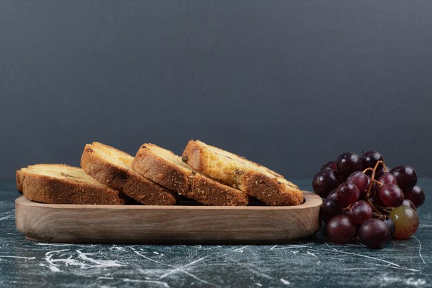 Rebanadas de pastel con pasas y uvas sobre fondo de mármol. Foto de alta calidad