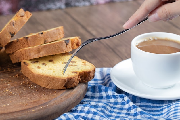 Rebanadas de pastel en un plato de madera con una taza de café