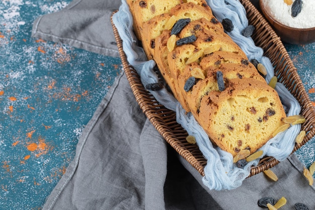 Rebanadas de pastel con sultana negra en canasta de madera.