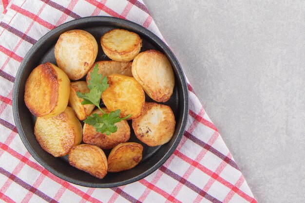 Rebanadas de patatas fritas en placa negra.