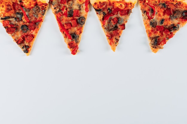Foto gratuita rebanadas de una pizza sobre un fondo de estuco brillante