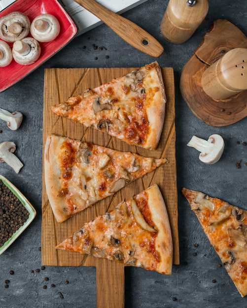 Rebanadas de pizza en una tabla de bambú de madera