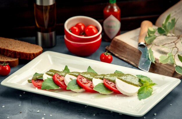 Rebanadas de queso blanco y tomate en hojas