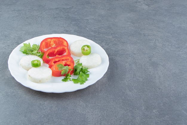 Foto gratuita rebanadas de queso y pimiento en un plato blanco.