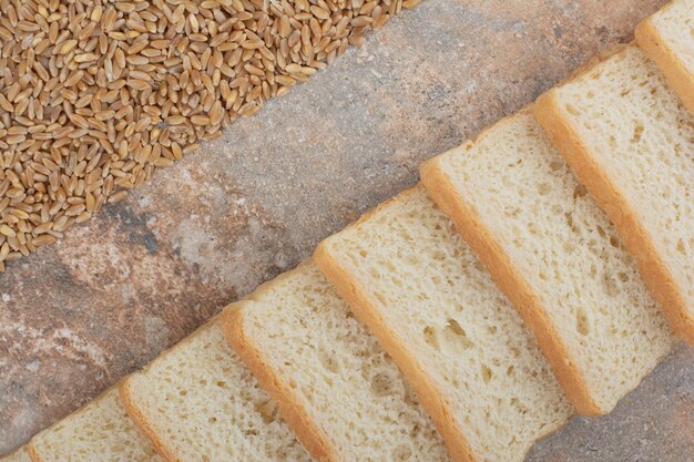 Rebanadas de tostadas blancas con cebada sobre fondo de mármol