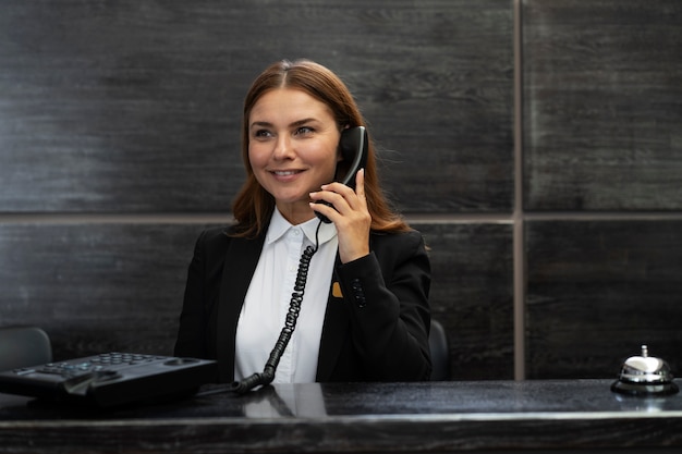 Foto gratuita recepcionista femenina con traje elegante durante las horas de trabajo