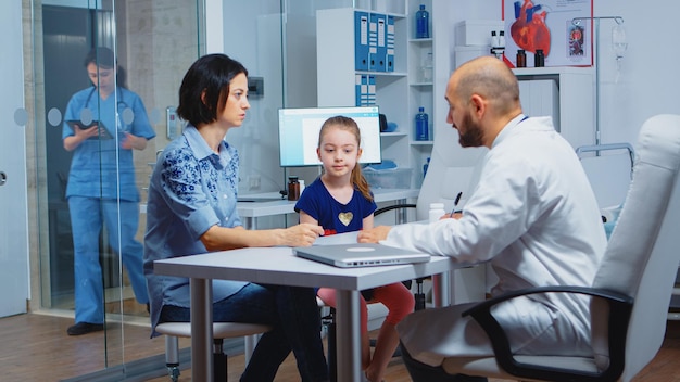 Receta de escritura de pediatra para niños después del examen. Profesional de la salud, médico, especialista en medicina que brinda servicios de atención médica, consulta, tratamiento de diagnóstico en el hospital.