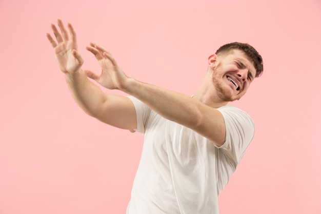 Rechazo, rechazo, concepto de duda. Hombre dudoso con expresión pensativa haciendo elección. Joven emocional. Las emociones humanas, el concepto de expresión facial. Estudio. Aislado en rosa de moda