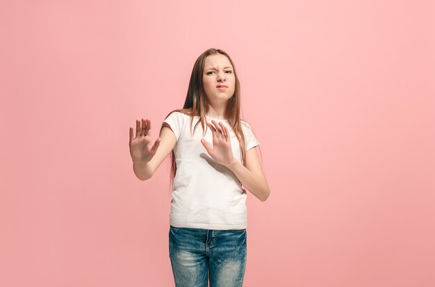 Rechazo, rechazo, concepto de duda. Joven adolescente emocional en rechazar algo contra la pared rosa. Las emociones humanas, el concepto de expresión facial.