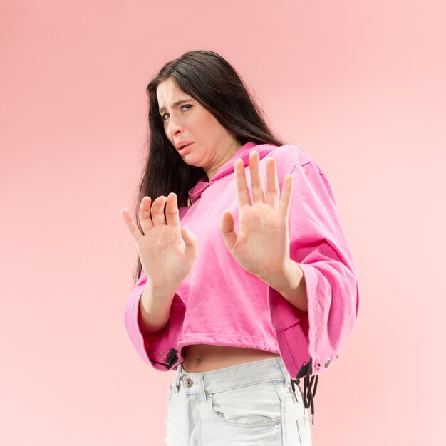 Rechazo, rechazo, concepto de duda. Mujer dudosa con expresión pensativa haciendo elección. Joven mujer emocional. Las emociones humanas, el concepto de expresión facial. Estudio. Aislado en rosa de moda