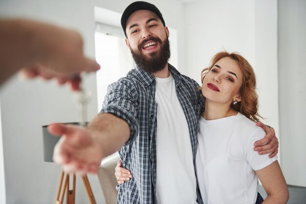 Recibiendo llaves. Pareja feliz juntos en su nueva casa. Concepción de mudanza