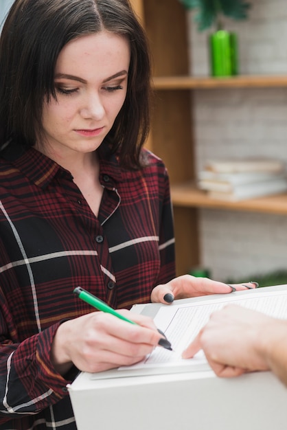 Foto gratuita recibo de firma de mujer joven para el paquete