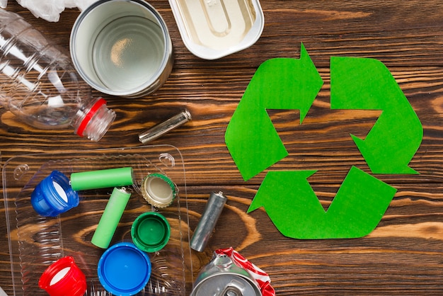 Recicle el logotipo y la basura reciclable en el escritorio de madera