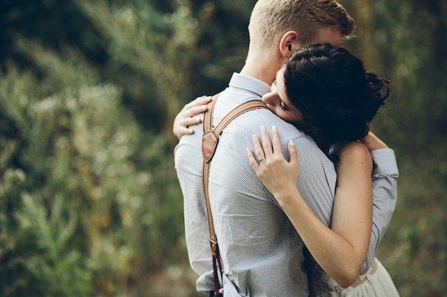 Recién casados abrazados en el bosque