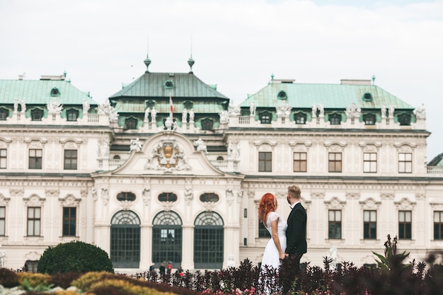 Recién casados admirando un edificio clásico