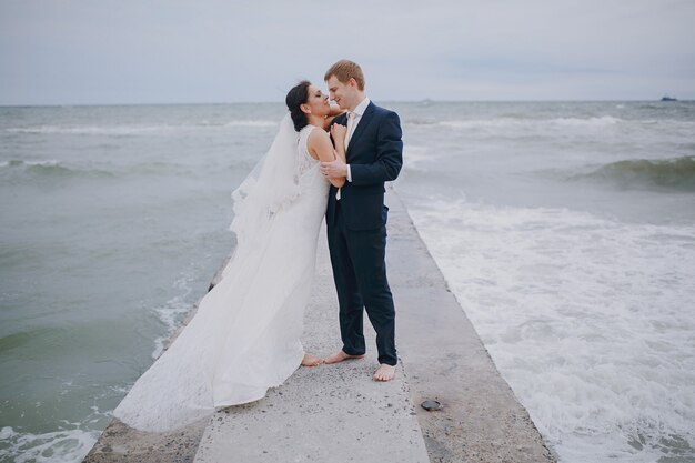 Recién casados besándose en el mar