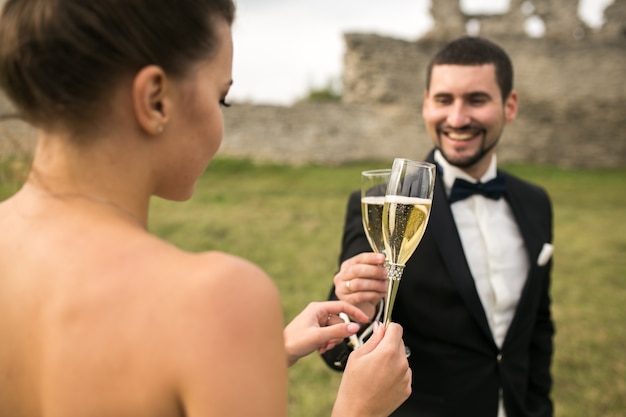 Recién casados brindando visto desde el hombro de la novia