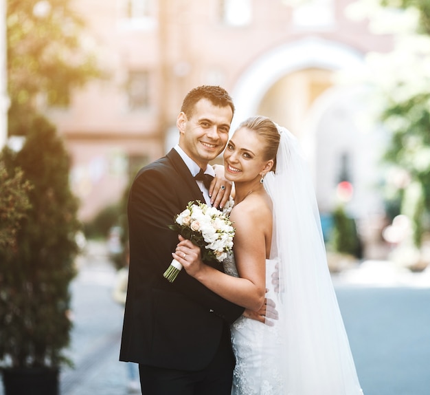 Foto gratuita recién casados felices abrazándose