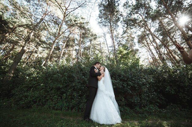 Recién casados felices mirándose al aire libre