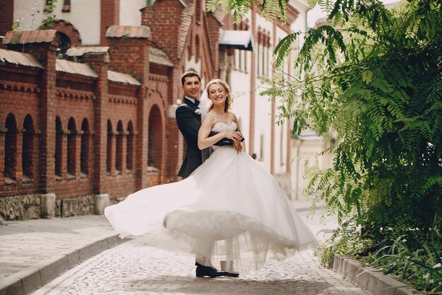 Recién casados felices posando en el pueblo