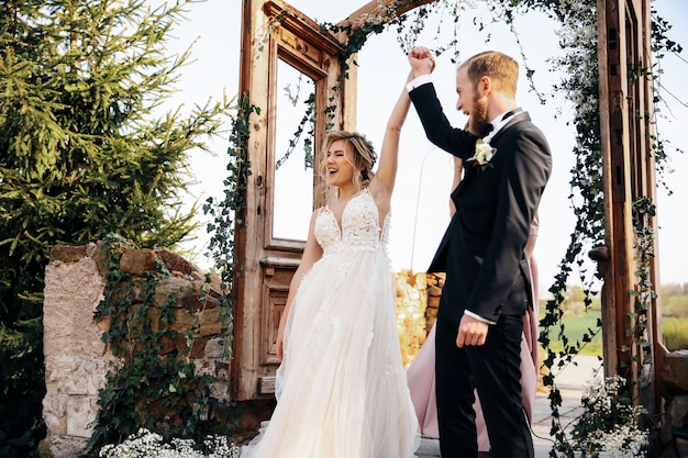 Recién casados levantando las manos después de la ceremonia de boda terminada