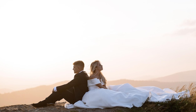 Recién casados en las montañas disfrutando del atardecer