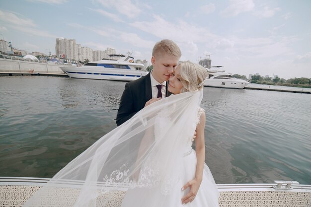 Recién casados posando con el muelle de fondo