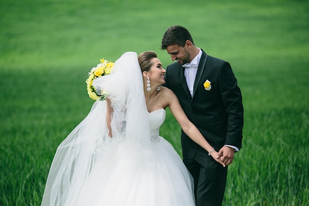 Recién casados románticos riendo en el prado