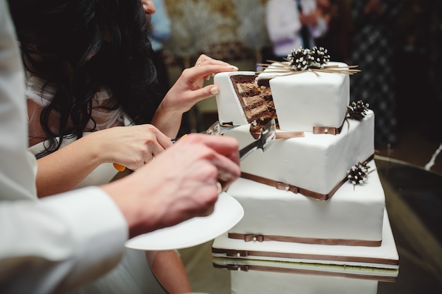 Foto gratuita recién casados sacando un trozo del pastel nupcial