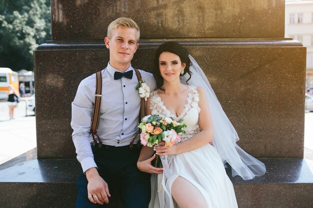 Recién casados sentados en la calle