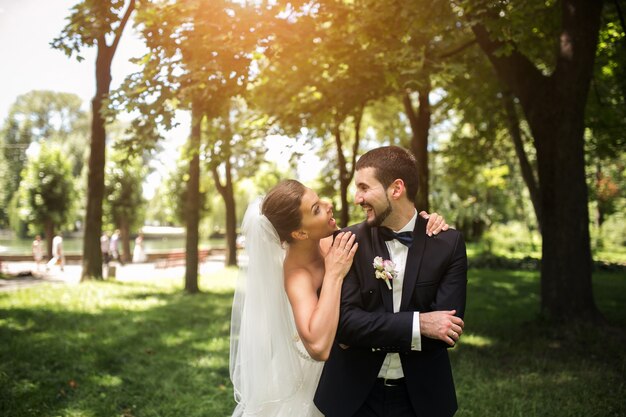 Recién casados sonriendo en el parque